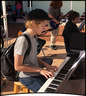 Student plays piano outside