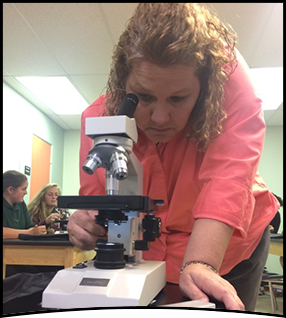 Staff member uses microscope